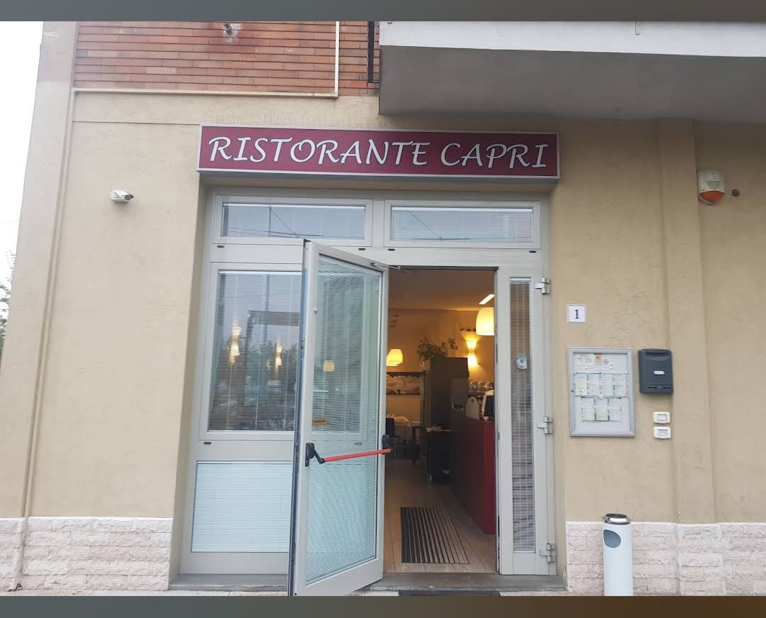 L'ingresso del Ristorante Capri con l'insegna bordeaux in Via Don Elio Monari, Modena